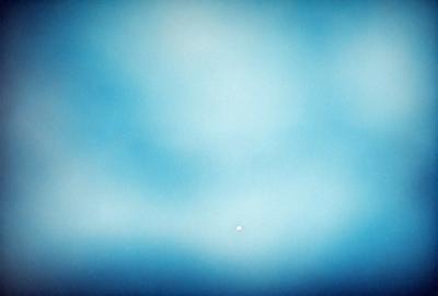 The primary subject of the image is a blue sky with clouds. The setting is a vast, open space with no visible landmarks or objects. The visual style is a natural, outdoor scene. The colors and mood are predominantly blue, creating a calm and serene atmosphere.