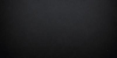 The primary subject of the image is a black background. The setting is a dark room, and the visual style is a black and white photo. The colors and mood of the image are dark and moody, creating a dramatic atmosphere.