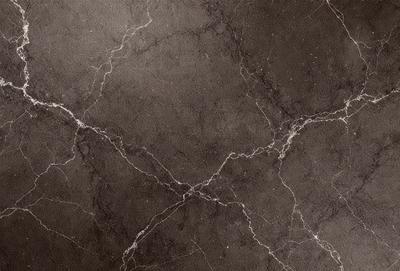 The primary subject of the image is a close-up of a marble tile wall. The setting is a room with a dark background, which highlights the marble tile. The visual style is a photo, capturing the intricate details of the marble tile. The colors and mood of the image are predominantly dark, with the marble tile being the main focus.