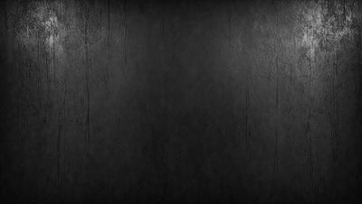 The primary subject of the image is a black wall with a texture that appears to be a combination of a brick wall and a leather-like surface. The setting is a dark room, and the visual style is a close-up of the wall. The colors and mood of the image are predominantly dark, with the black wall being the main focus.