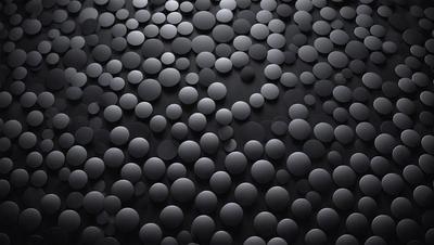 The primary subject of the image is a black background with a pattern of round circles. The circles are of various sizes and are scattered across the background. The setting appears to be a dark room, and the visual style is a close-up of the circles. The overall atmosphere is somewhat mysterious and intriguing due to the black background and the presence of the round circles.
