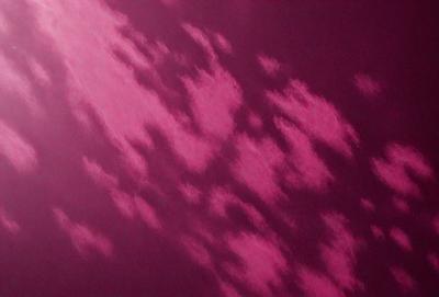 The primary subject of the image is a purple background with a cloudy pattern. The setting is a dark, cloudy sky, and the visual style is a combination of a photo and digital art. The dominant colors are purple and pink, creating a moody and atmospheric mood.