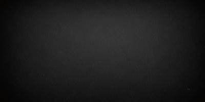 The primary subject of the image is a black background. The setting is a dark, empty space. The visual style is a black and white photo. The colors and mood are dark and moody.