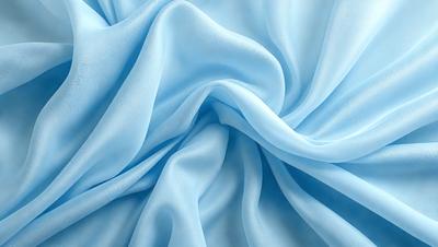 The primary subject of the image is a blue fabric, which appears to be a piece of silk. The setting is a close-up of the fabric, showcasing its texture and details. The visual style is a realistic representation of the fabric, capturing its natural appearance. The colors and mood of the image are predominantly blue, creating a calm and serene atmosphere.