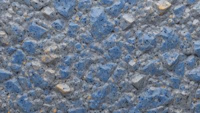 The primary subject of the image is a blue and yellow rocky surface. The setting is a rocky wall, and the visual style is a photo. The dominant colors are blue and yellow, creating a vibrant and lively atmosphere.