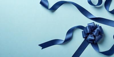 The primary subject of the image is a blue ribbon. The ribbon is tied in a bow and is placed on a blue surface. The setting appears to be a room with a blue wall. The visual style of the image is a close-up of the blue ribbon, showcasing its texture and details. The colors and mood of the image are predominantly blue, creating a calm and serene atmosphere.