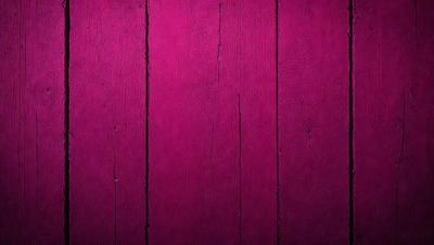 The primary subject of the image is a wooden wall with a pinkish hue. The setting is a room with a wooden surface, and the visual style appears to be a photo. The dominant colors in the image are pink and brown, creating a warm and inviting atmosphere.