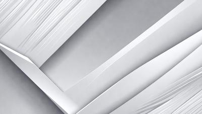 The primary subject of the image is a stack of white paper. The setting is a gray background, which creates a contrast with the white paper. The visual style is a close-up of the paper, showcasing its texture and details. The colors and mood of the image are predominantly white, giving it a clean and minimalist appearance.
