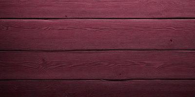 The primary subject of the image is a wooden surface, possibly a deck or a wall, with a red color. The setting is outdoors, and the visual style appears to be a photo. The dominant colors are red and brown, creating a warm and inviting atmosphere.