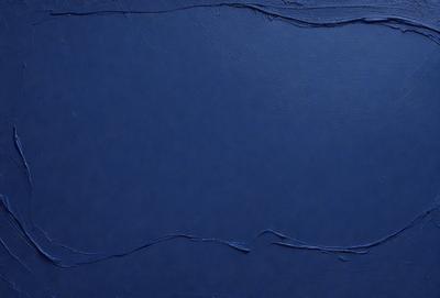 The primary subject of the image is a blue leather surface. The setting is a dark room, and the visual style is a close-up of the leather surface. The colors and mood of the image are predominantly dark and moody, with the blue leather serving as the main focal point.