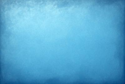 The primary subject of the image is a large, open, and cloudy blue sky. The setting is a vast expanse of the sky, with no visible land or other objects. The visual style is a natural, outdoor scene, with no indication of digital art or illustration. The colors and mood of the image are predominantly blue, creating a serene and peaceful atmosphere.