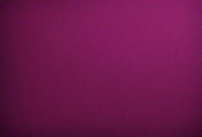 The primary subject of the image is a large, purple wall. The setting is a room with a pink background. The visual style is a close-up of the purple wall, which gives a sense of depth and texture. The dominant colors are purple and pink, creating a warm and inviting atmosphere.