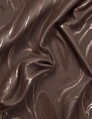 The primary subject of the image is a close-up of a dark, shiny, and textured surface, possibly a piece of chocolate or a dark fabric. The setting is a close-up of the surface, with no background visible. The visual style appears to be a close-up of a textured surface, possibly a piece of chocolate or a dark fabric. The colors and mood of the image are dark and shiny, creating a visually appealing and intriguing scene.