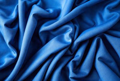 The primary subject of the image is a blue fabric, which is the main object, scene, or focus of the image. The setting or background is a blue cloth, and the visual style is a photo. The dominant colors and overall atmosphere are blue and serene.