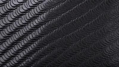 The primary subject of the image is a black leather material, which appears to be a leather-like fabric or a leather-like pattern. The setting is a black background, which contrasts with the leather material. The visual style is a close-up of the leather material, showcasing its texture and pattern. The colors and mood of the image are predominantly black, giving it a sleek and modern appearance.