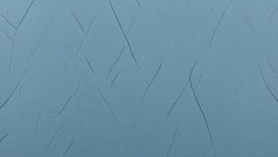 The primary subject of the image is a blue wall with a pattern of cuts or scratches on it. The setting is a room with a blue background. The visual style is a close-up of the blue wall with the cuts. The colors and mood of the image are predominantly blue, creating a calm and serene atmosphere.