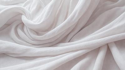 The primary subject of the image is a white sheet or blanket, which is the main object, scene, or focus of the image. The setting or background is a white surface, which could be a wall or a table. The visual style of the image is a close-up of the white sheet, showcasing its texture and details. The colors and mood of the image are predominantly white, giving it a clean and serene atmosphere.