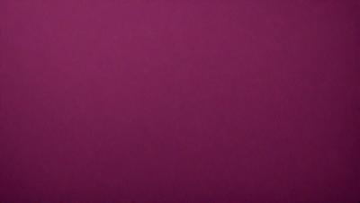 The primary subject of the image is a large, purple wall. The setting is a room with a pink background. The visual style is a close-up of the wall, which gives a sense of depth and texture. The dominant colors are purple and pink, creating a warm and inviting atmosphere.