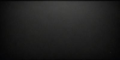 The primary subject of the image is a black background with a leather texture. The setting is a dark room, and the visual style is a close-up of the leather surface. The colors and mood of the image are predominantly dark and moody, with the black background and leather texture creating a dramatic and intense atmosphere.