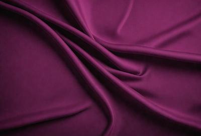The primary subject of the image is a purple fabric, which is the main object, scene, or focus of the image. The setting or background is a purple cloth, and the visual style is a close-up of the fabric. The colors and mood of the image are predominantly purple, creating a calm and soothing atmosphere.