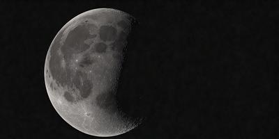 Primary subject: A moon with a dark background.

Setting/background: The moon is in the sky, with a dark background.

Visual style: The image is a photo of the moon.

Colors and mood: The image has a black and white color scheme, giving it a classic and timeless appearance.