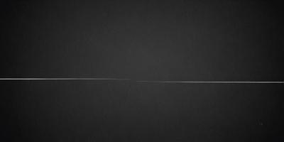 The primary subject of the image is a white line on a black background. The setting is a dark, empty space, and the visual style appears to be a simple, minimalist design. The colors are predominantly black and white, creating a stark and dramatic atmosphere.