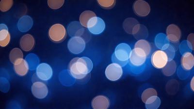 The primary subject of the image is a blue background with a pattern of white lights. The setting appears to be a nighttime scene, possibly a cityscape or a dark room with a light source. The visual style of the image is a combination of a photo and digital art, creating a unique and captivating atmosphere. The dominant colors are blue and white, with the white lights creating a sense of depth and contrast against the dark blue background.