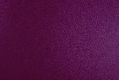 The primary subject of the image is a purple leather surface. The setting is a close-up of the leather, showcasing its texture and color. The visual style is a realistic representation of the leather, with no indication of digital art or illustration. The colors and mood of the image are predominantly purple, creating a calm and sophisticated atmosphere.