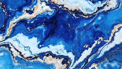 The primary subject of the image is a blue and gold marbled stone. The setting is a blue and gold marbled stone surface, which serves as the background. The visual style is a close-up of the marbled stone, showcasing its intricate patterns and colors. The dominant colors are blue and gold, creating a rich and luxurious atmosphere.
