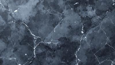 The primary subject of the image is a close-up of a marble surface with a pattern of holes and bumps. The setting is a dark room, and the visual style appears to be a photo. The dominant colors are black and white, giving the image a classic and elegant appearance. The overall atmosphere is one of sophistication and timeless beauty.