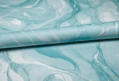 The primary subject of the image is a blue and white striped fabric. The setting is a table, and the visual style appears to be a photo. The colors and mood of the image are predominantly blue and white, creating a calm and soothing atmosphere.