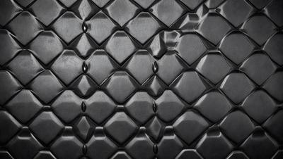 The primary subject of the image is a close-up of a black and white patterned surface, which appears to be a textured wall or a black and white tile. The setting is indoors, and the visual style is a close-up of the patterned surface. The colors and mood of the image are predominantly black and white, giving it a classic and timeless appearance.
