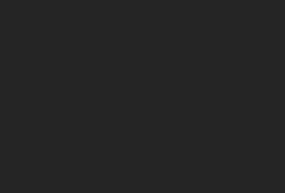 The primary subject of the image is a black background. The setting/background is a dark, empty space. The visual style is a black and white photo. The colors and mood are dark and moody.