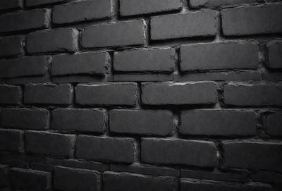 The primary subject of the image is a brick wall. The setting is a dark room, and the visual style is a black and white photo. The dominant colors are black and white, creating a moody atmosphere.