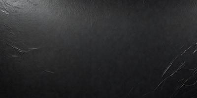 The primary subject of the image is a black leather surface. The setting is a black background, and the visual style is a close-up of the leather. The colors and mood of the image are dark and moody, with the black leather being the dominant color.