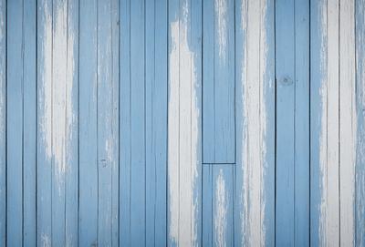 The primary subject of the image is a blue and white wooden floor. The setting is a room with a blue wall, and the visual style is a photo. The colors and mood of the image are predominantly blue and white, creating a calm and serene atmosphere.