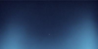 Primary subject: A blue sky with a moon visible.

Setting/background: The sky is clear and blue, with no clouds or other objects visible.

Visual style: The image is a photo of the sky.

Colors and mood: The sky is predominantly blue, and the overall atmosphere is calm and serene.