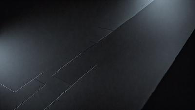 The primary subject of the image is a black surface with a metal piece sticking out of it. The setting appears to be a dark room, and the visual style is a close-up of the metal piece. The colors in the image are predominantly black, giving it a moody and mysterious atmosphere.