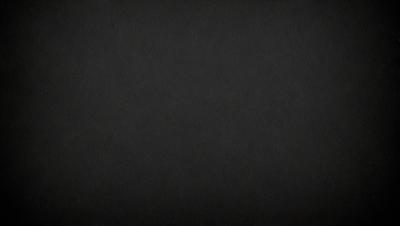 The primary subject of the image is a black background. The setting is a dark, empty space, with no visible objects or elements. The visual style is a black and white photo, which gives the image a classic and timeless appearance. The colors and mood are predominantly dark and moody, creating a sense of mystery and depth.