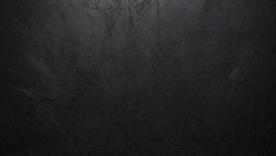 The primary subject of the image is a black leather surface. The setting is a dark room, and the visual style is a close-up of the leather surface. The colors and mood of the image are predominantly dark and moody, with the black leather being the main focus.