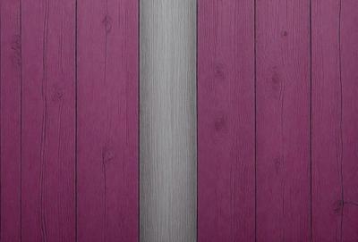 The primary subject of the image is a wooden wall with a purple stripe. The setting is a room with a wooden wall, and the visual style is a photo. The dominant colors are purple and brown, creating a warm and inviting atmosphere.