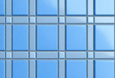 The primary subject of the image is a blue tile with a pattern of white squares. The setting is a bathroom, as indicated by the blue tiles. The visual style is a photo, capturing the intricate pattern of the blue and white tiles. The colors and mood of the image are predominantly blue and white, creating a clean and modern atmosphere.