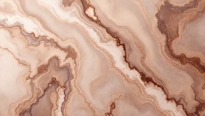 The primary subject of the image is a marble-like surface with a pattern of swirls and crevices. The setting is a close-up of the marble, showcasing its intricate texture. The visual style is a realistic representation of the marble, capturing its natural beauty. The colors and mood of the image are predominantly earthy tones, giving it a natural and timeless appearance.