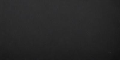 The primary subject of the image is a black leather surface. The setting is a dark room, and the visual style is a close-up of the leather surface. The colors and mood of the image are predominantly dark and moody, with the black leather serving as the main focal point.