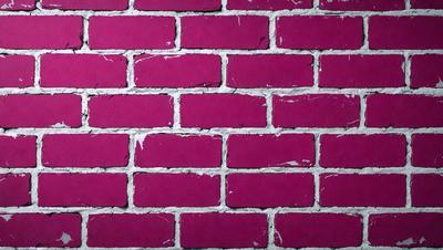 The primary subject of the image is a brick wall, which is the main object, scene, or focus of the image. The setting/background features a pink brick wall, which is the environment, backdrop, or surface visible in the image. The visual style of the image is a photo, as it is a real-life brick wall. The dominant colors in the image are pink, which creates a warm and inviting atmosphere.
