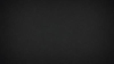 The primary subject of the image is a black background. The setting is a dark room, and the visual style is a black and white photo. The colors and mood of the image are predominantly dark and moody, with a sense of mystery and depth.
