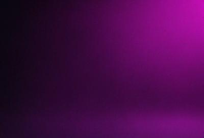 The primary subject of the image is a purple wall. The setting is a dark room, and the visual style appears to be a photo. The dominant colors are purple and black, creating a moody atmosphere.