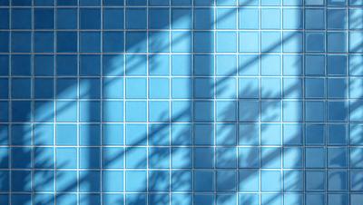 The primary subject of the image is a blue tile wall with a pattern of blue and white squares. The setting is a room with a blue tile floor, and the visual style is a photo. The dominant colors are blue and white, creating a calm and soothing atmosphere.