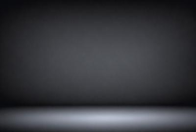 The primary subject of the image is a black background. The setting is a dark room, and the visual style is a black and white photo. The colors and mood are dark and moody, creating a sense of mystery or drama.
