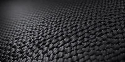 The primary subject of the image is a close-up of a black, textured surface. The setting appears to be a black background, which creates a striking contrast with the textured surface. The visual style of the image is a close-up, which emphasizes the details of the textured surface. The colors in the image are predominantly black, giving the image a bold and striking appearance.